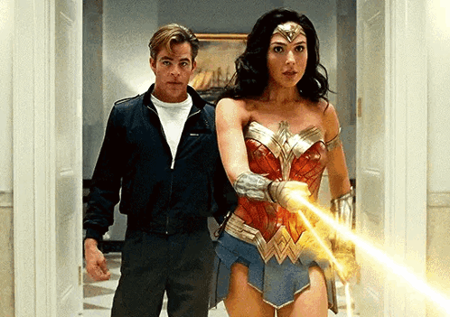 A Man And A Woman Are Standing Next To Each Other In A Hallway Holding A Light . GIF