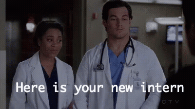 A Man And A Woman Are Standing Next To Each Other In A Hospital Room . GIF