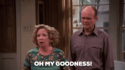 A Man And A Woman Are Standing Next To Each Other In A Living Room . GIF