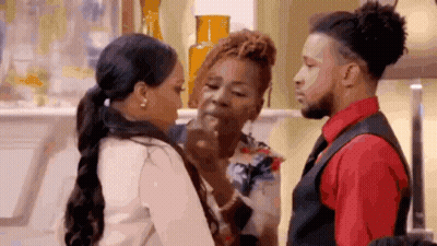 A Man And A Woman Are Standing Next To Each Other In A Living Room . GIF