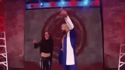 A Man And A Woman Are Standing Next To Each Other In A Ring . GIF