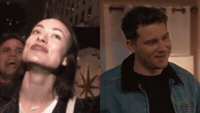 A Man And A Woman Are Standing Next To Each Other In A Room GIF
