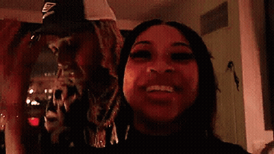 a man and a woman are standing next to each other in a room and smiling .