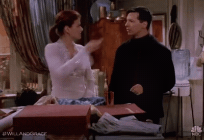 A Man And A Woman Are Standing Next To Each Other In A Room And Talking . GIF
