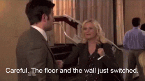 A Man And A Woman Are Standing Next To Each Other In A Room And Talking . GIF