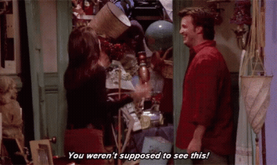 A Man And A Woman Are Standing Next To Each Other In A Room Filled With Lots Of Objects . GIF