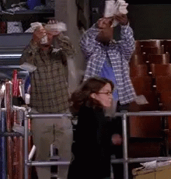 A Man And A Woman Are Standing Next To Each Other In A Room . GIF