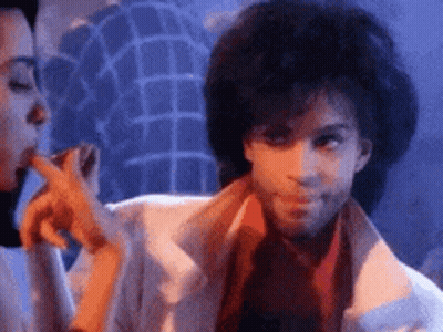 A Man And A Woman Are Standing Next To Each Other In A Room . GIF