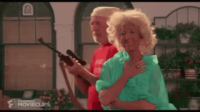 A Man And A Woman Are Standing Next To Each Other In A Room Holding A Gun . GIF