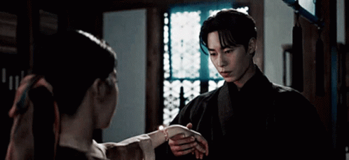 A Man And A Woman Are Standing Next To Each Other In A Room . GIF