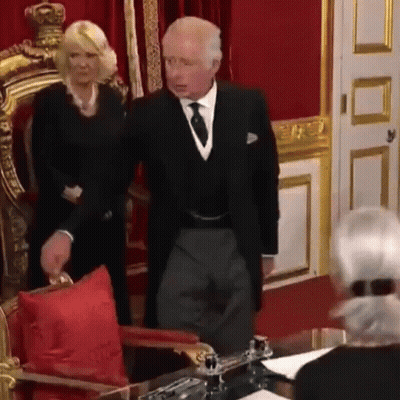 A Man And A Woman Are Standing Next To Each Other In A Room . GIF