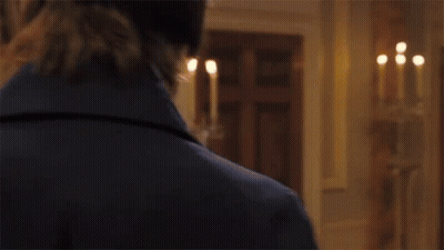 A Man And A Woman Are Standing Next To Each Other In A Room . The Woman Is Wearing A White Dress . GIF