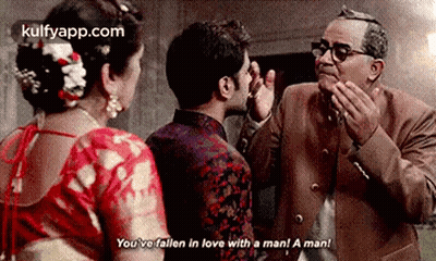 A Man And A Woman Are Standing Next To Each Other In A Room . GIF