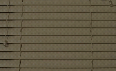 A Man And A Woman Are Standing Next To Each Other In A Room With A Staircase In The Background . GIF