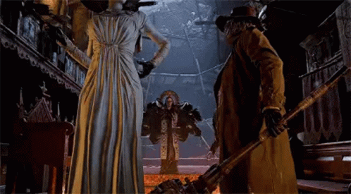 A Man And A Woman Are Standing Next To Each Other In A Room . GIF