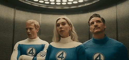 A Man And A Woman Are Standing Next To Each Other In An Elevator Wearing Fantastic Four Costumes . GIF