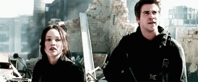 A Man And A Woman Are Standing Next To Each Other In Front Of A Building . GIF