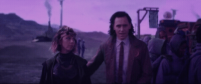 A Man And A Woman Are Standing Next To Each Other In Front Of A Purple Sky . GIF