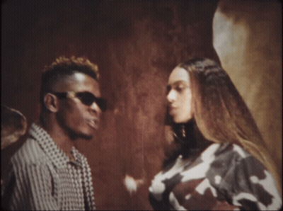 A Man And A Woman Are Standing Next To Each Other Looking At Each Other GIF