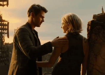 A Man And A Woman Are Standing Next To Each Other Looking At Each Other GIF