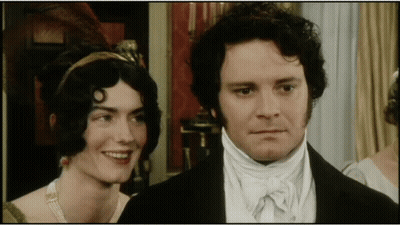 A Man And A Woman Are Standing Next To Each Other GIF
