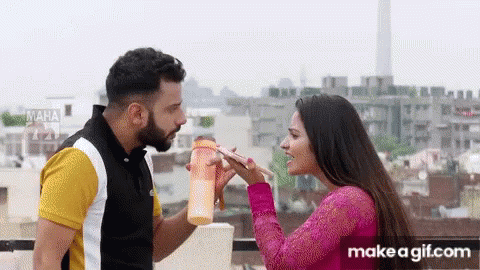 A Man And A Woman Are Standing Next To Each Other On A Balcony . GIF