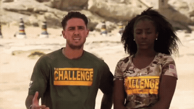 A Man And A Woman Are Standing Next To Each Other On A Beach Wearing Shirts That Say Challenge . GIF