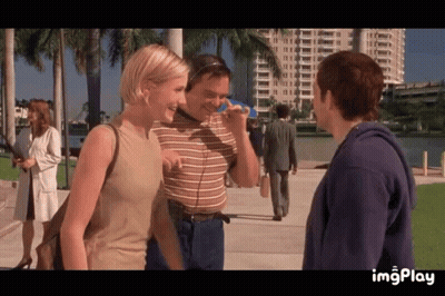 A Man And A Woman Are Standing Next To Each Other On A Sidewalk With The Word Imgplay At The Bottom Of The Screen GIF