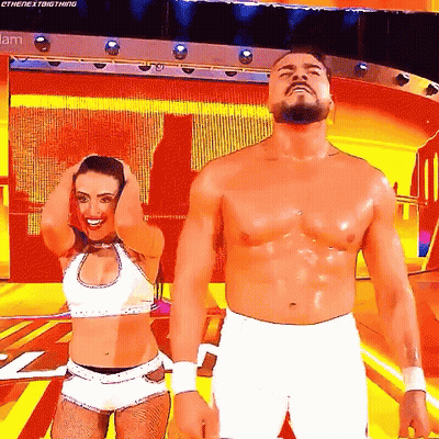 A Man And A Woman Are Standing Next To Each Other On A Stage With Their Hands In Their Hair . GIF