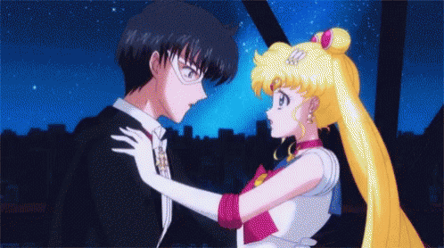 A Man And A Woman Are Standing Next To Each Other GIF