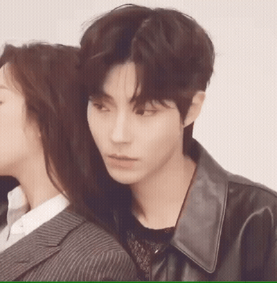 A Man And A Woman Are Standing Next To Each Other . The Man Is Wearing A Leather Jacket . GIF