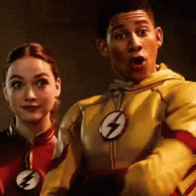 A Man And A Woman Are Standing Next To Each Other . The Man Is Wearing A Yellow Flash Suit . GIF