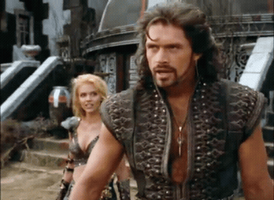 A Man And A Woman Are Standing Next To Each Other . GIF