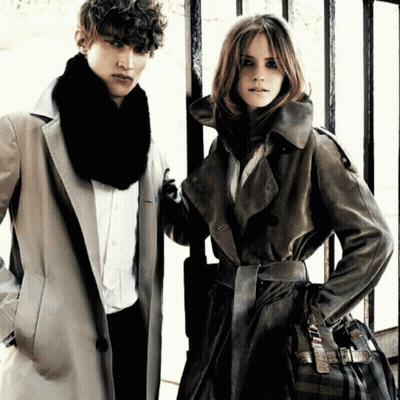 A Man And A Woman Are Standing Next To Each Other Wearing Coats GIF