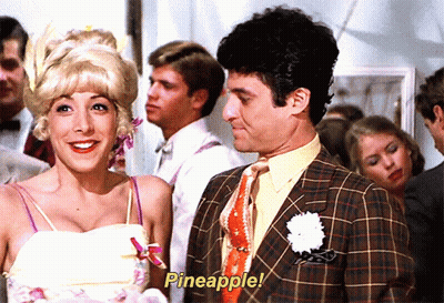 A Man And A Woman Are Standing Next To Each Other With Pineapple Written On The Screen GIF