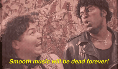 A Man And A Woman Are Standing Next To Each Other With Smooth Music Will Be Dead Forever Written In Yellow GIF