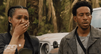 A Man And A Woman Are Standing Next To Each Other With The F9 Logo On The Bottom Right GIF