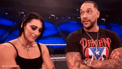 A Man And A Woman Are Standing Next To Each Other With The Man Wearing A Shirt That Says Dawn GIF