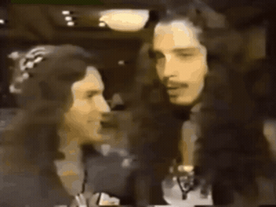 A Man And A Woman Are Standing Next To Each Other With The Name Chris Cornell On The Bottom Right GIF