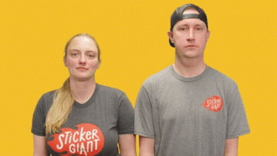 A Man And A Woman Are Standing Next To Each Other With The Word Awkward Written On Their Shirts GIF