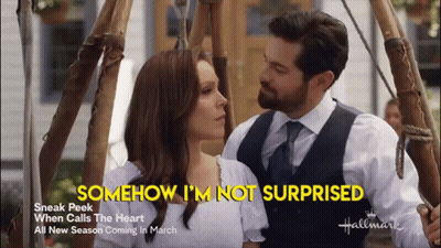 A Man And A Woman Are Standing Next To Each Other With The Words Somehow I 'M Not Surprised Behind Them GIF