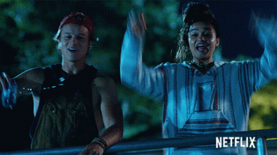 a man and a woman are standing next to each other with their arms in the air and the word netflix is on the bottom