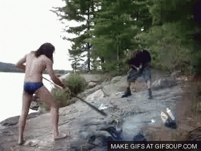 A Man And A Woman Are Standing On A Rocky Shore . GIF