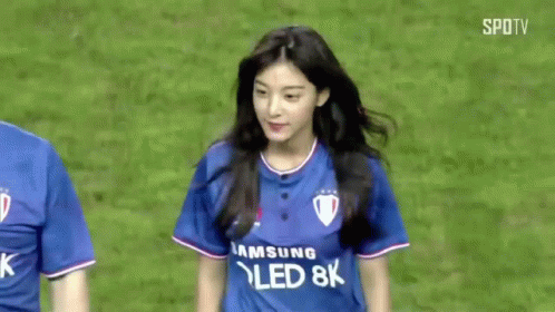 A Man And A Woman Are Standing On A Soccer Field . The Woman Is Wearing A Samsung Qled 8K Shirt . GIF
