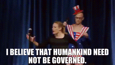 A Man And A Woman Are Standing On A Stage With A Microphone In Their Hands . GIF