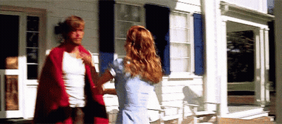 A Man And A Woman Are Standing Outside Of A White House . GIF