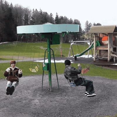 A Man And A Woman Are Swinging On A Green Swing Set GIF