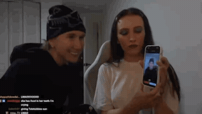 A Man And A Woman Are Taking A Picture Of Each Other With A Cell Phone . GIF