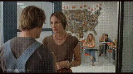 A Man And A Woman Are Talking In A Classroom With A Map Of The United States In The Background . GIF