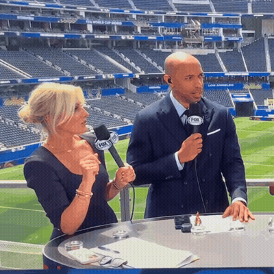 A Man And A Woman Are Talking Into Microphones That Say Fox On Them GIF